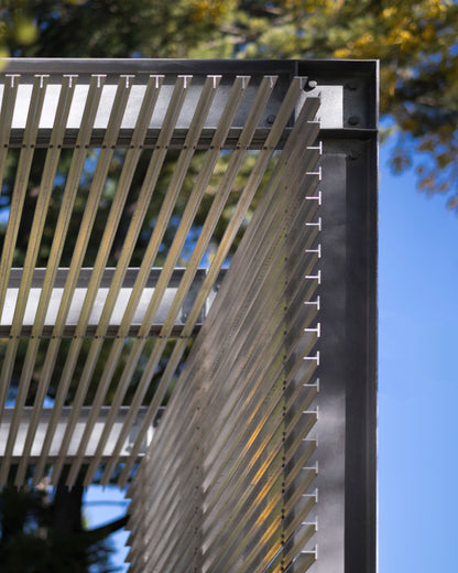 Modern Sunroom addition with exposed structural framing, Sun screen made up of standard metal sections. Akar Architecture.